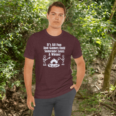 Our Camping tee features two adorable stick figure people roasting wieners over a cozy campfire. And with the hilarious slogan "It's All Fun & Games Until Someone Loses A Wiener," you'll be the life of the party at any camping trip!